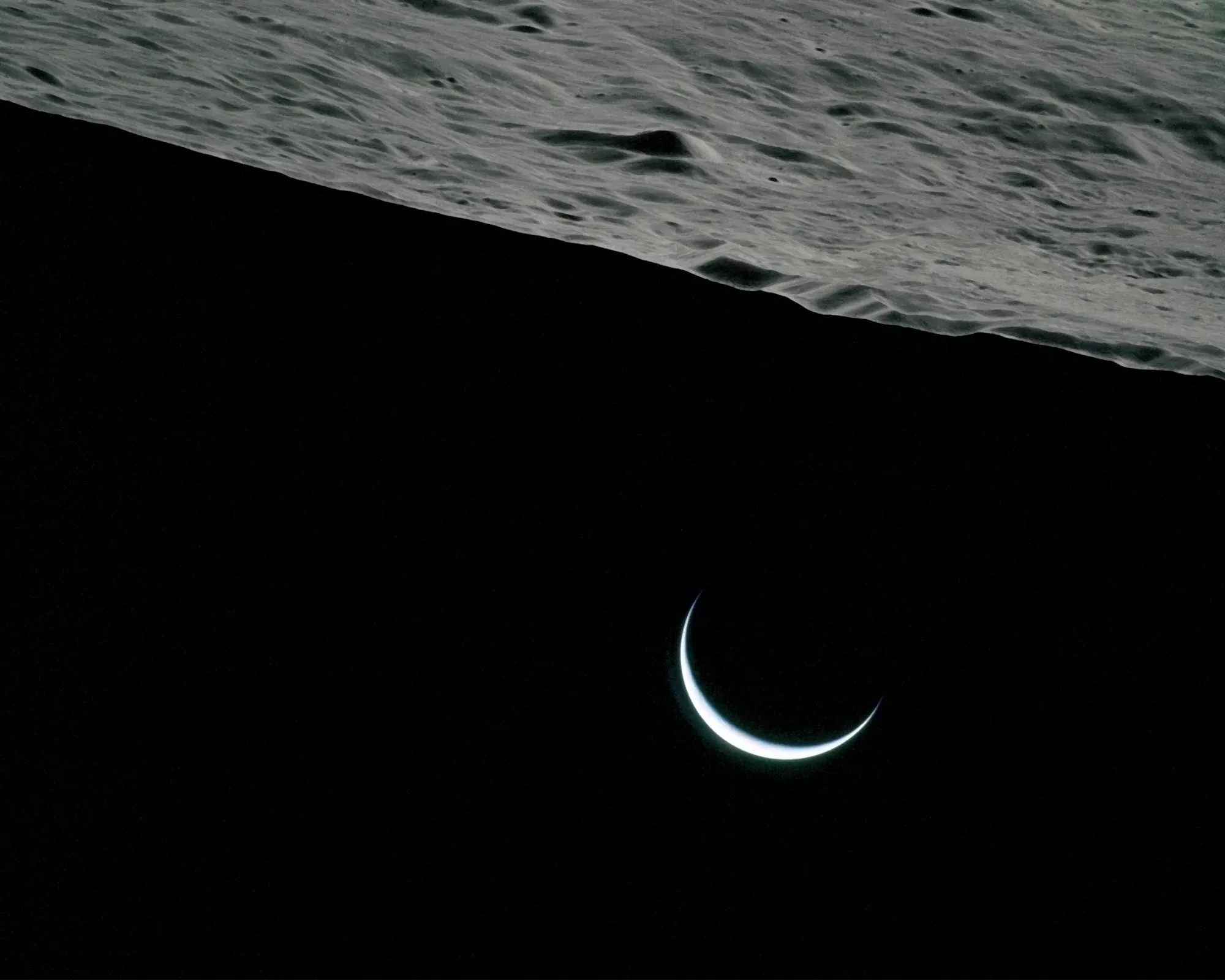 Crescent Earth emerging beneath the moon’s rugged surface, symbolizing bold new horizons